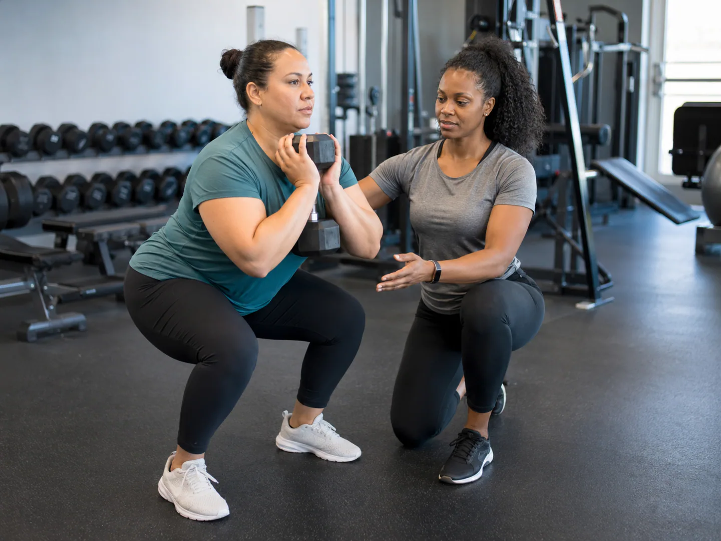 Personal trainer coaching a client through safe supervised exercise